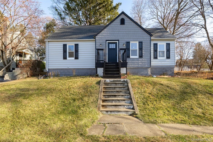 Cape Cod with a front lawn and roof with shingles