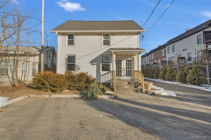 View of front of house with a shingled roof