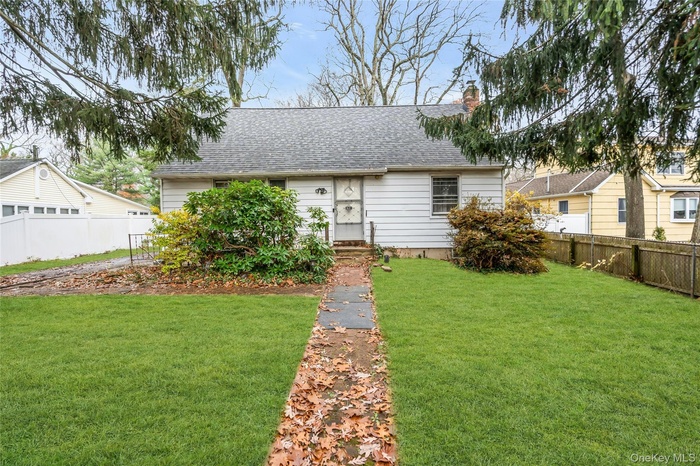 View of front of property featuring a shingled roof and a chimney