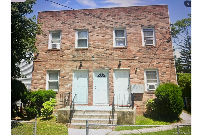 View of front facade featuring a fenced front yard and brick siding