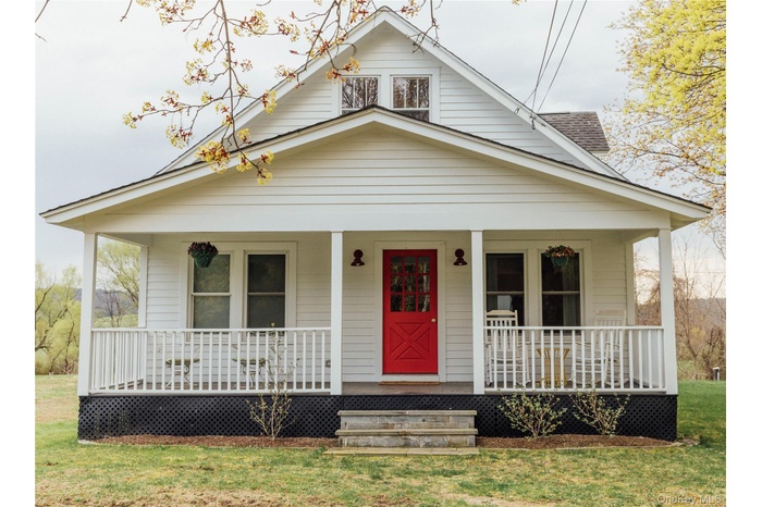 Bungalow-style home with covered porch and a front lawn