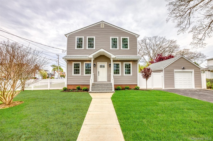 View of front of house featuring an outbuilding, a detached garage, and asphalt driveway