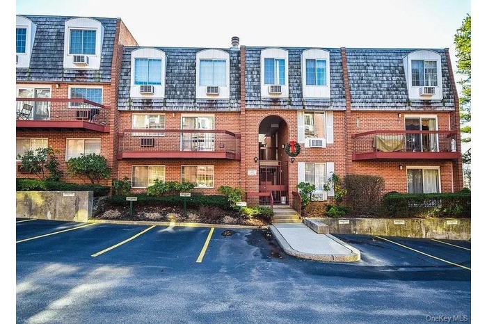 View of apartment building / complex with uncovered parking