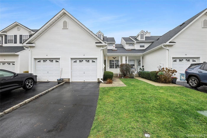 Traditional-style home with a porch, asphalt driveway, and a front lawn