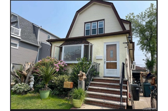 Colonial inspired home with a gambrel roof and stucco siding