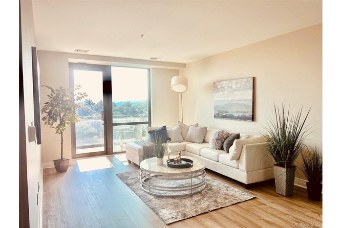 Living area with expansive windows and light wood finished floors
