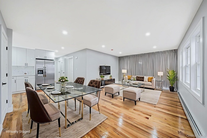 Dining room featuring a baseboard radiator, light wood finished floors, and recessed lighting