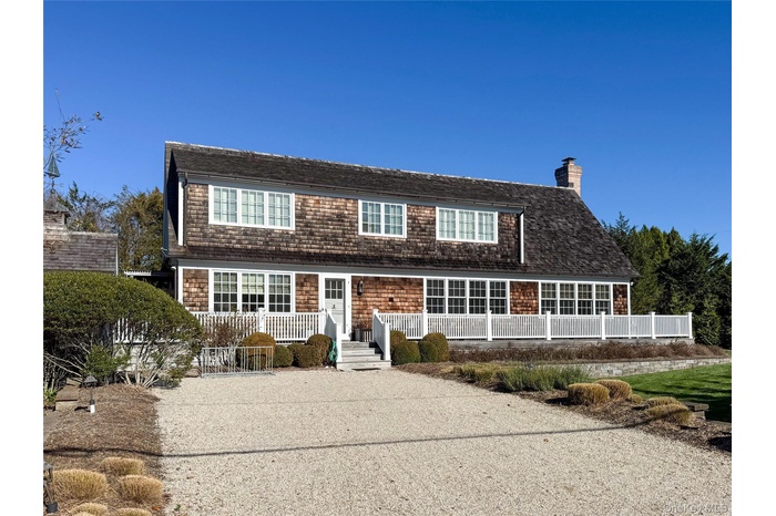 View of front of home featuring a chimney and roof with shingles
