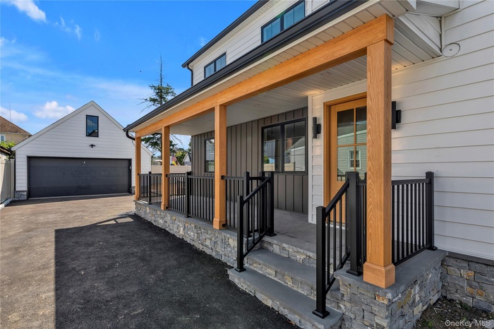 Entrance to property with a porch and a garage
