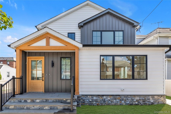 View of front facade with board and batten siding and a porch