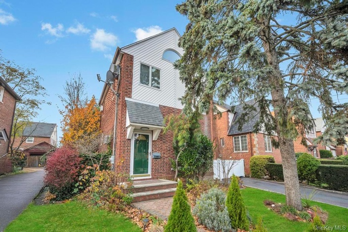 View of front of house with brick siding and a shingled roof