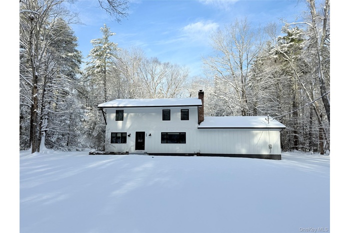 View of front facade with a chimney and a forest view