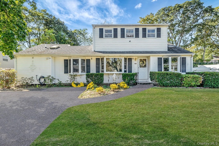 Traditional-style house featuring a front lawn and roof with shingles