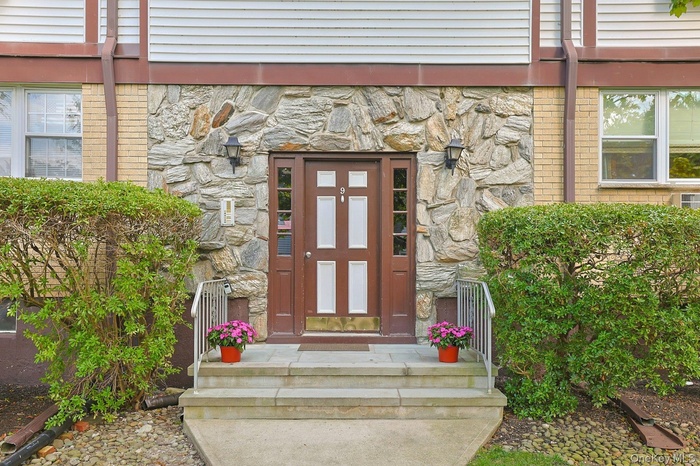 Entrance to property featuring stone siding