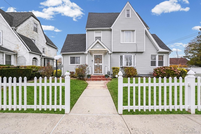View of front of property featuring a shingled roof and a fenced front yard