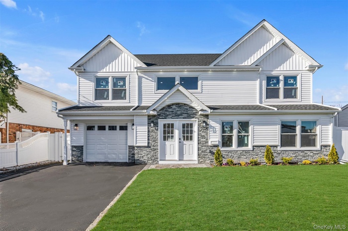 Craftsman inspired home featuring stone siding, board and batten siding, driveway, roof with shingles, and an attached garage