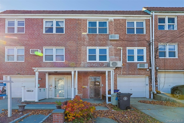 Traditional home featuring brick siding, covered porch, driveway, and an attached garage