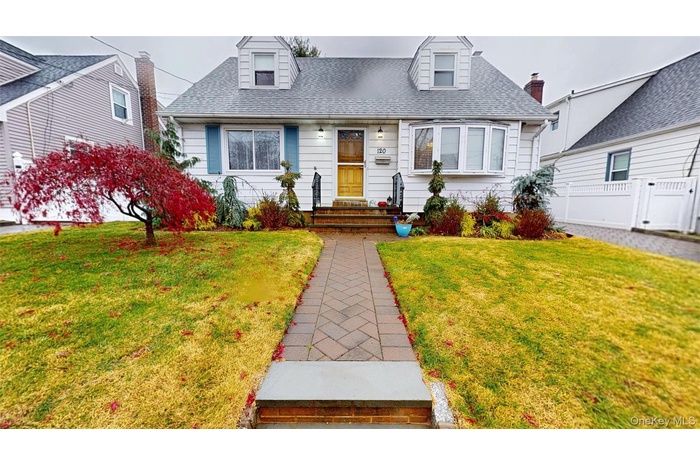 Cape cod home with roof with shingles and a front lawn