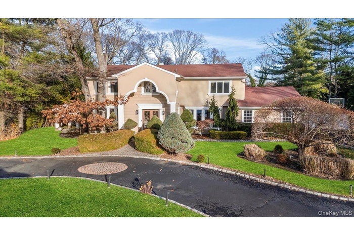 View of front facade featuring a front lawn and stucco siding
