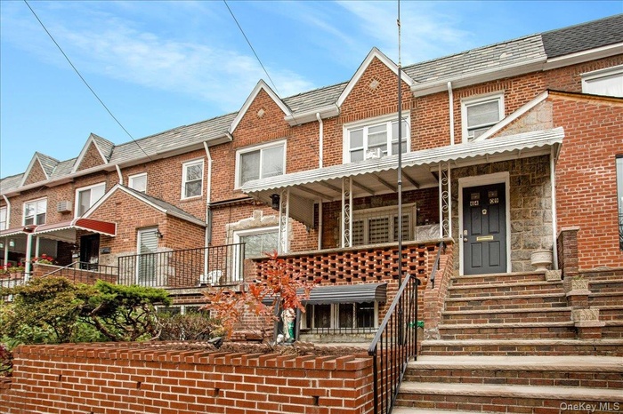 View of front of house with covered porch and brick siding