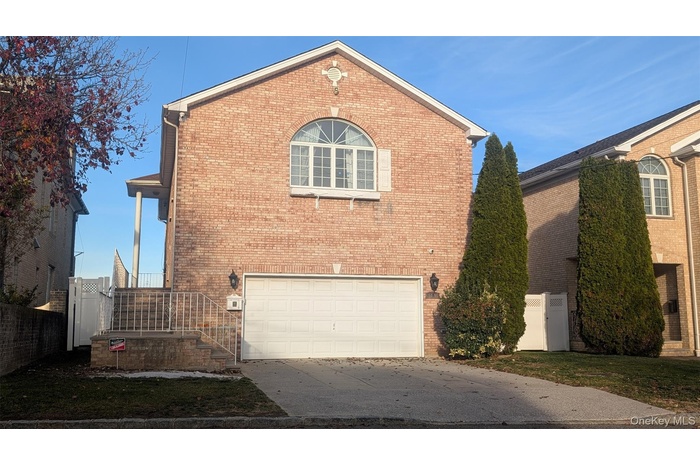 View of side of home featuring brick siding, concrete driveway, and an attached garage