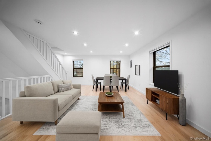 Living room with recessed lighting, light wood-style flooring, and stairway