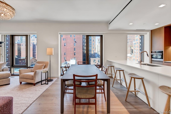 Dining area featuring light wood finished floors, healthy amount of natural light, a city view, and recessed lighting