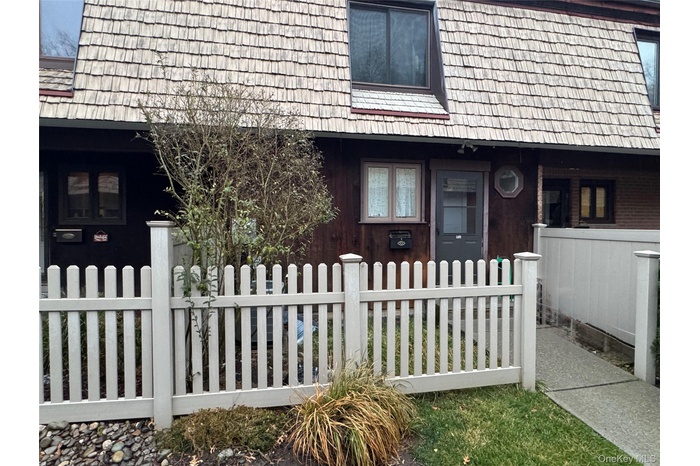 Property entrance featuring mansard roof and covered porch