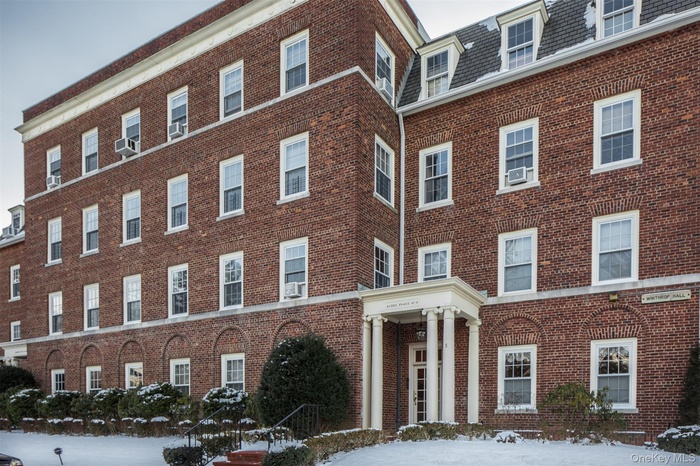 Snow covered property featuring a view of apartment building / complex