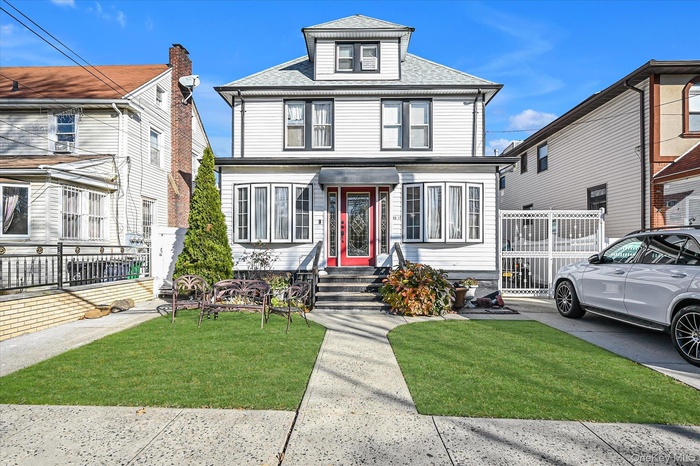 American foursquare style home featuring a shingled roof