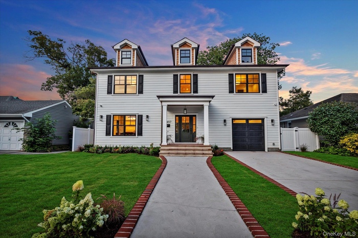 View of front of property featuring driveway, a gate, and a garage