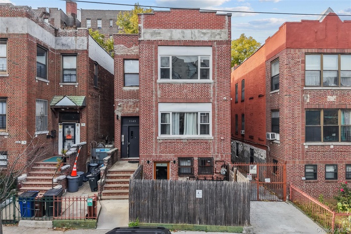 Traditional home featuring brick siding, a gate, and a fenced front yard