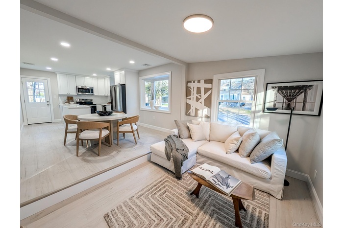 Living room with recessed lighting and light wood-type flooring