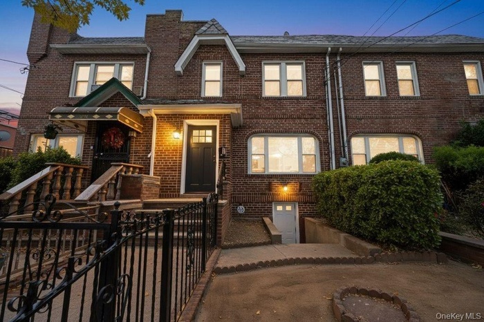 View of front of property featuring brick siding, a chimney, and a fenced front yard