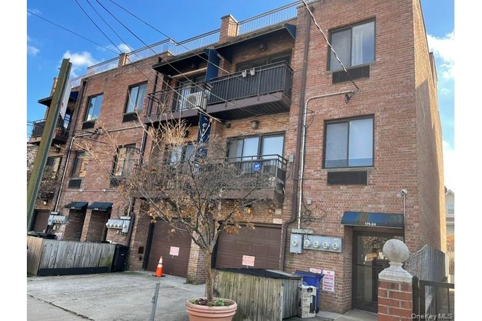 View of apartment building / complex with concrete driveway and an attached garage