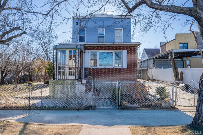 View of front of house featuring a gate, brick siding, and a fenced front yard