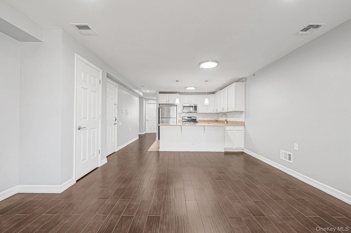 Unfurnished living room featuring wood tiled floors