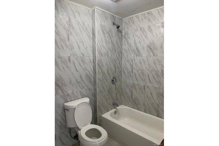Bathroom with tile walls and tub / shower combination