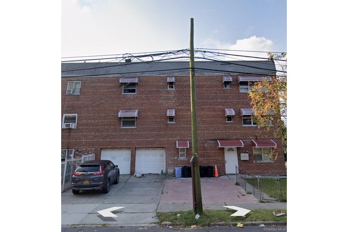View of apartment building / complex with driveway and a garage