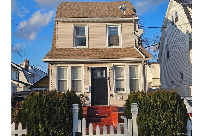 View of front facade featuring a fenced front yard and a shingled roof