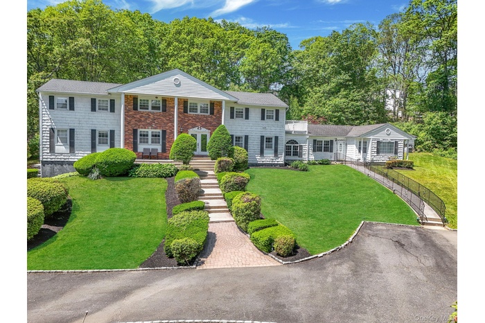 Neoclassical / greek revival house featuring a front yard