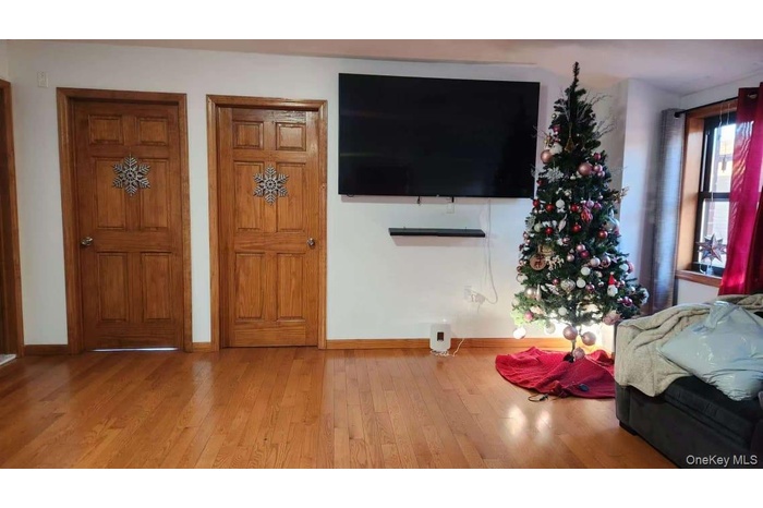 Living area featuring baseboards and wood-type flooring