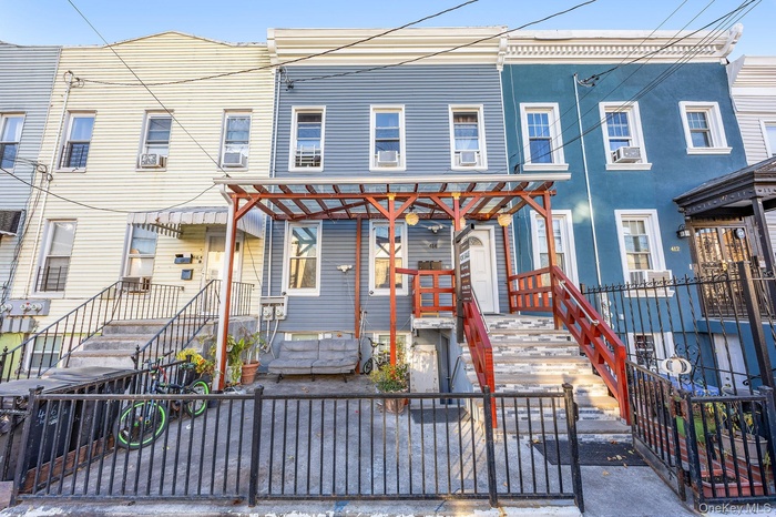 View of front facade featuring a fenced front yard, stucco siding, and a gate