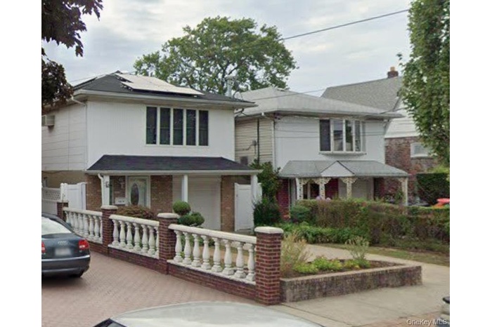 Traditional style home featuring roof mounted solar panels, covered porch, and driveway