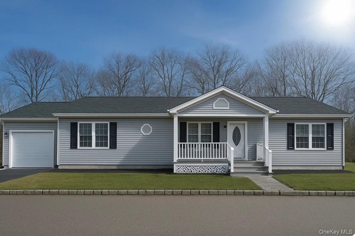 Single story home with a porch, a front yard, and a garage