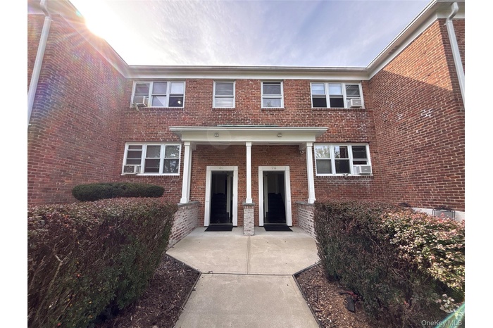 View of front facade featuring brick siding and covered porch