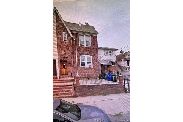 View of front of house with brick siding and a fenced front yard