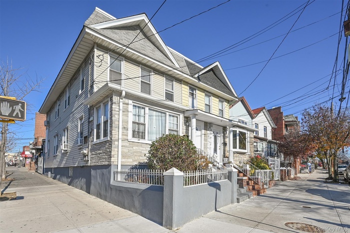 View of front of house with a fenced front yard, stone siding, and a residential view