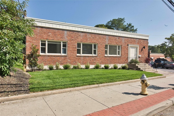 View of front of house with a front yard and brick siding