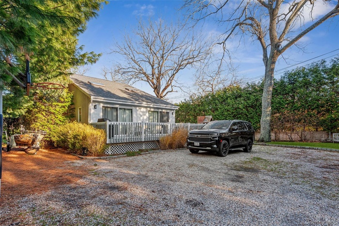 View of front of home with a deck and roof with shingles